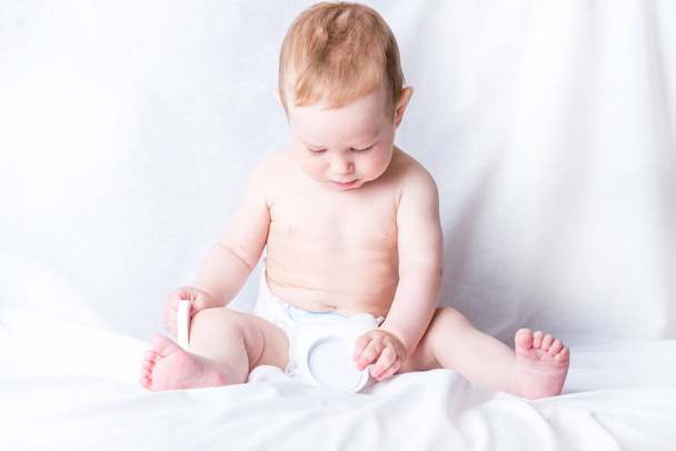 Mignon bébé aux yeux bleus 6-9 mois souriant et jouant sur fond blanc. Les émotions des enfants. Propreté et soins pour bébés
 - Photo, image