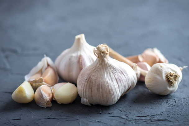Gruppo di spicchi d'aglio sparsi su un tavolo su fondo bianco. Un ingrediente importante nelle diverse cucine del mondo. Un prodotto sano
. - Foto, immagini