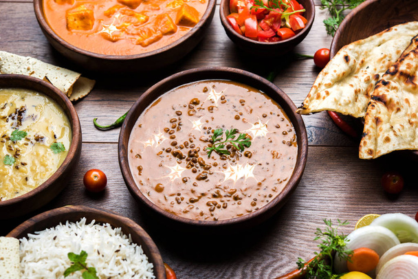 Assorted indian food for lunch or dinner, rice, lentils, paneer, dal makhani, naan, chutney, spices over moody background. selective focus - 写真・画像