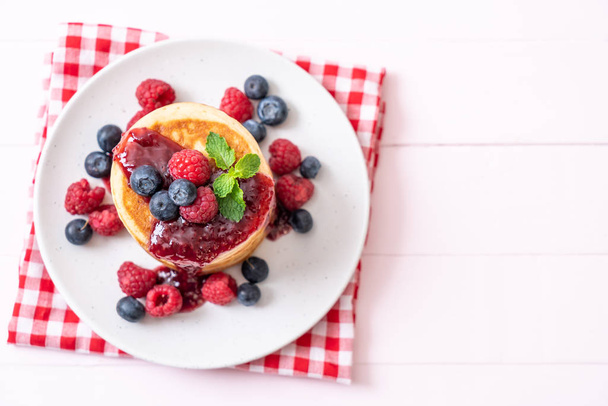 souffle pancake with fresh raspberries and blueberries - Foto, Imagen