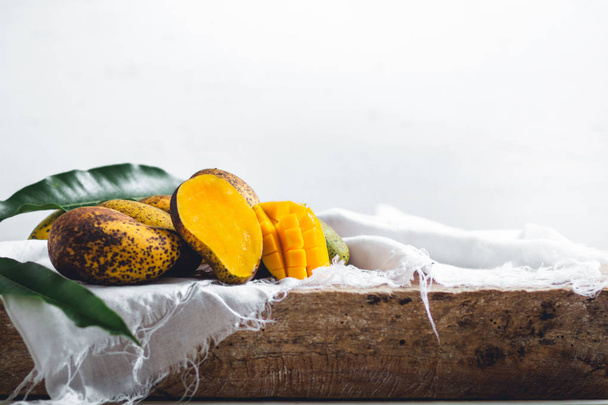Natuur mango op een houten plaat en het witte doek  - Foto, afbeelding