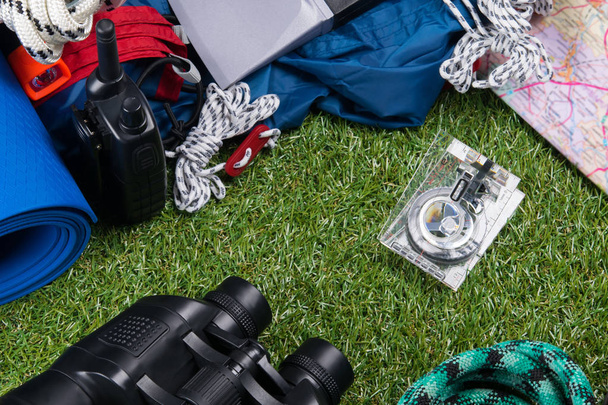 set of items for outdoor recreation, tent, thermal mug, ax and binoculars with compass. - Foto, imagen