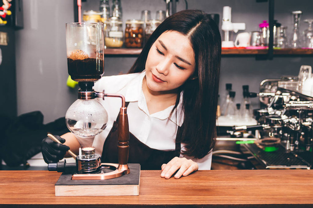 Women Barista making coffee on syphon coffee maker in the cafe - Photo, Image