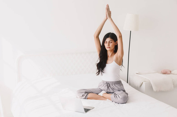 Woman practicing yoga at home in bedroom - Foto, Imagen