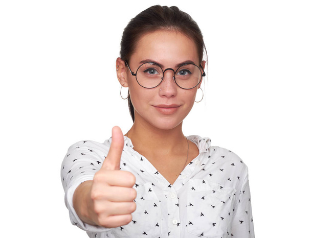 Happy young woman giving thumbs up. pretty girl wearing eyeglasses and smiling. Isolated on white - Valokuva, kuva
