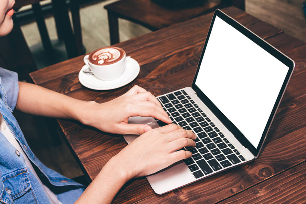 Женщина пьет кофе и работает за ноутбуком в кафе
 - Фото, изображение