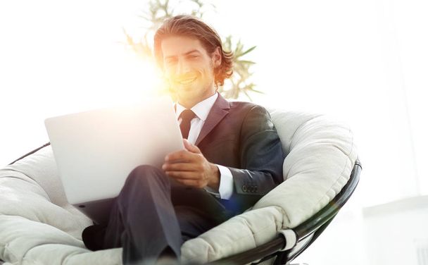 úspěšný podnikatel s notebookem sedět v velké pohodlné armchai - Fotografie, Obrázek
