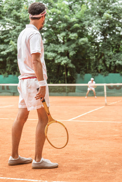 男のテニスコートで木製のラケットとテニスの背面図 - 写真・画像