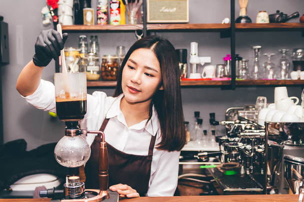 女性バリスタ カフェでサイフォン コーヒー メーカーでコーヒーを作る - 写真・画像