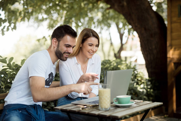glückliches Paar im Café, das mit dem Laptop arbeitet - Foto, Bild