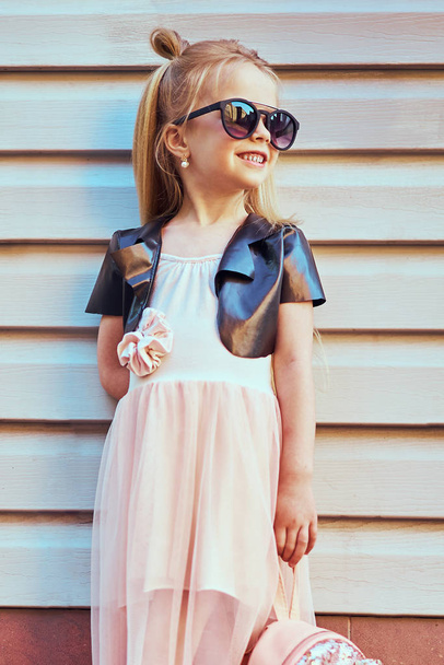 Lifestyle portrait of stylish little girl teenager. Beautiful child, wearing black jacket, pink skirt. Beautiful long hair. - Φωτογραφία, εικόνα