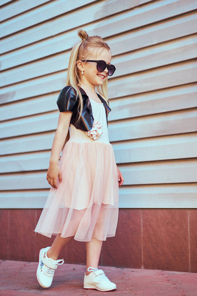 Lifestyle portrait of stylish little girl teenager. Beautiful child, wearing black jacket, pink skirt. Beautiful long hair. - Fotografie, Obrázek