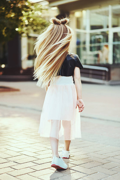 Lifestyle portrait of stylish little girl teenager. Beautiful child, wearing black jacket, pink skirt. Beautiful long hair. - Foto, Imagen