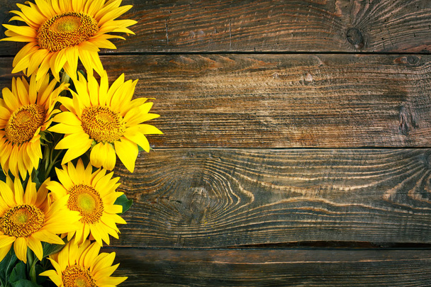 Beautiful sunflowers on a wooden table. View from above. Background with copy space. - Foto, immagini