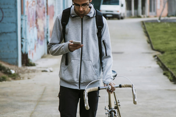 young in town with mobile phone and bike - Photo, Image