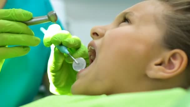 Childrens dentist drilling tooth to little girl, timely caries treatment - Filmati, video