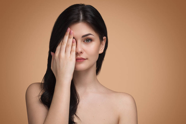 Cute woman covering eye with hand - Photo, Image