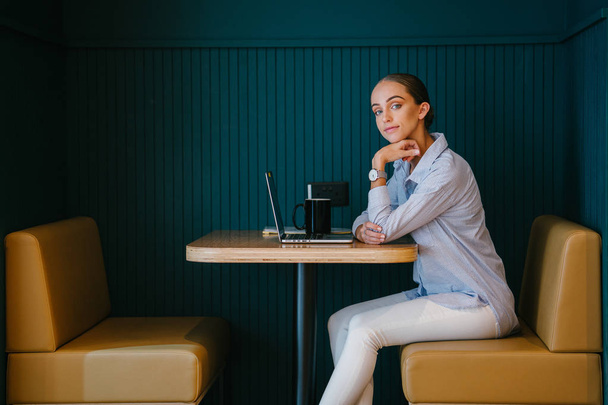 young confident businesswoman working on laptop sitting at table in modern office - Foto, Imagen