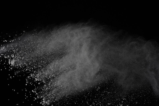 Freeze motion of white dust explosion on white background. Stop motion the movement of white powder on dark background. Explosive of white cloud on black background. - Photo, Image
