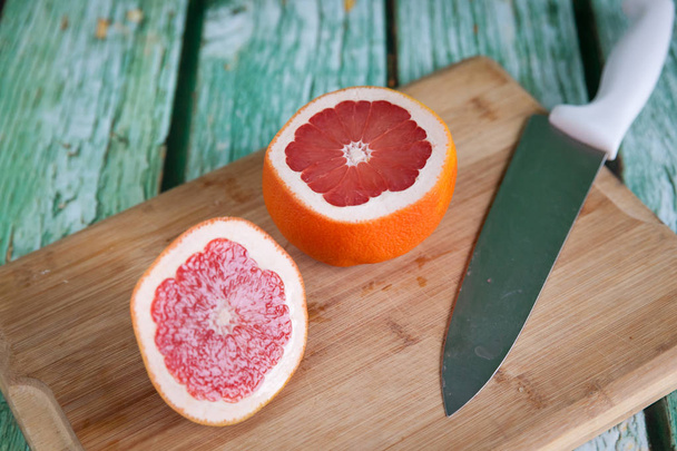 Sliced grapefruit on cutting board - Fotoğraf, Görsel