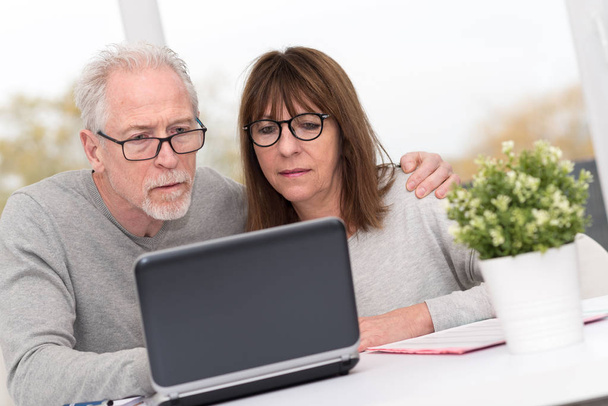 Couple mature utilisant un ordinateur portable à la maison
 - Photo, image