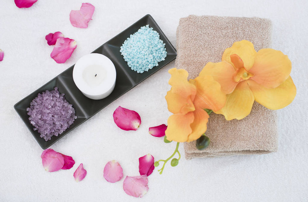 Αρωματικό κερί αξεσουάρ σπα, ορχιδέα λουλούδι, scrub αλάτι και πετσέτα. - Φωτογραφία, εικόνα