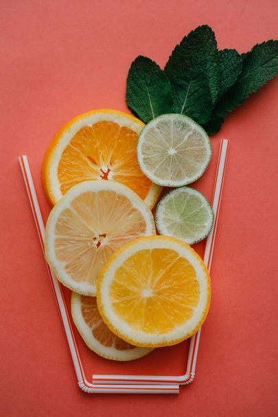 Εννοιολογική φωτογραφία. Εσπεριδοειδών λεμονάδα ή χυμό από φρέσκα φρούτα σε ένα ποτήρι των σωληναρίων - Φωτογραφία, εικόνα