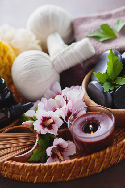 spa setting with hibiscus flowers on dark background,  thai herbal compress massage concept  - Photo, Image