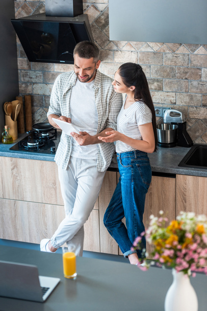 married couple using digital tablet together in kitchen, smart home concept - Photo, Image