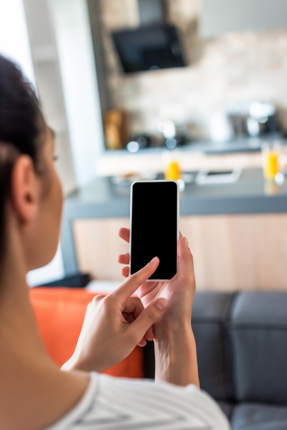 messa a fuoco selettiva della donna utilizzando smartphone con schermo bianco in cucina
 - Foto, immagini