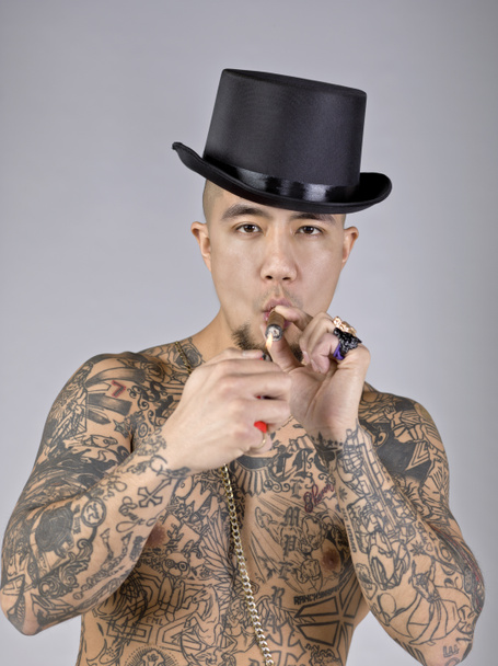 een man met tatoeage roken van een sigaret - Foto, afbeelding