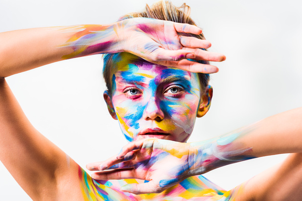 attraente ragazza con colorato brillante corpo arte toccare fronte e mento isolato su bianco
  - Foto, immagini