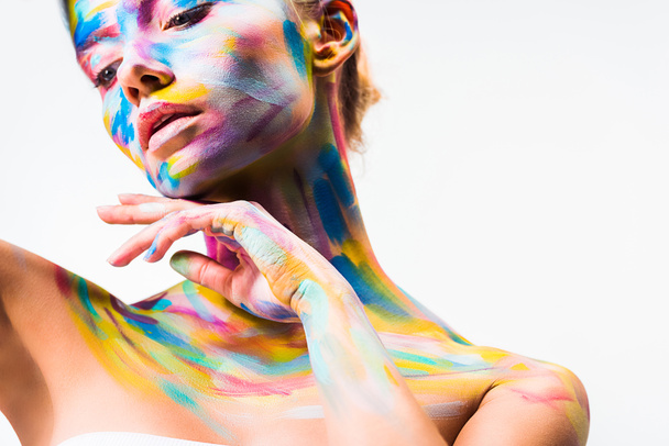 atractiva chica con colorido brillante cuerpo arte tocando cuello aislado en blanco
  - Foto, Imagen