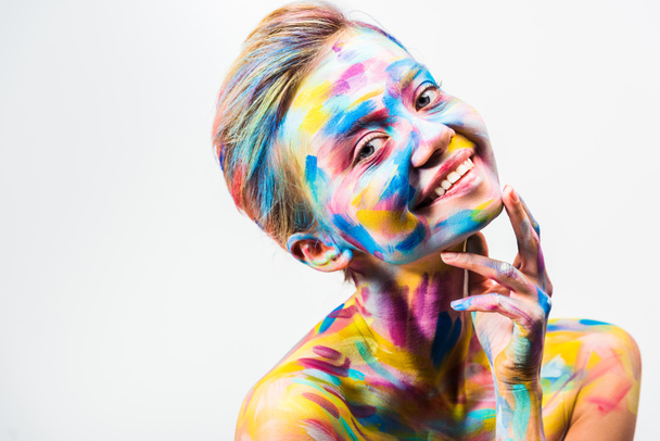 sonrisa atractiva chica con colorido brillante cuerpo arte tocando barbilla aislado en blanco
   - Foto, Imagen