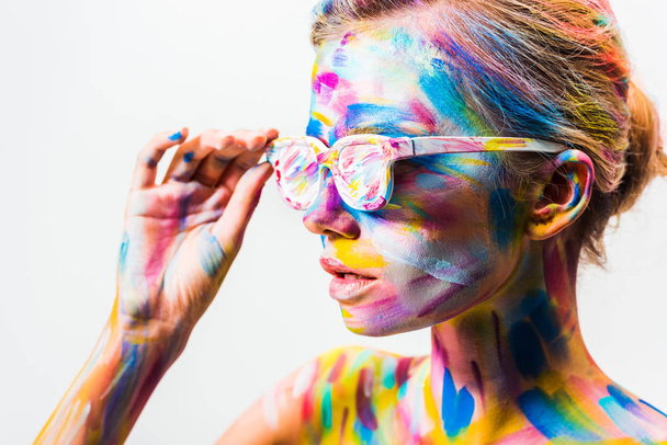 attractive girl with colorful bright body art touching sunglasses isolated on white - Foto, Bild