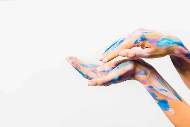 περικομμένη εικόνα του κοριτσιού με πολύχρωμο φωτεινό σώμα τέχνη που κάνουν τα κύματα με τα χέρια που απομονώνονται σε λευκό - Φωτογραφία, εικόνα