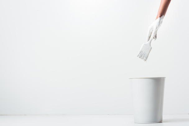 cropped image of girl holding painting brush with white paint above bucket - Fotografie, Obrázek