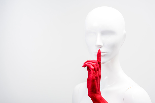 cropped image of woman in red paint showing silence gesture with mannequin isolated on white - Photo, Image