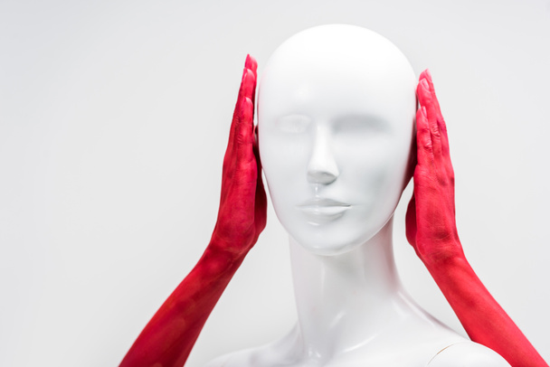 cropped image of woman in red paint covering mannequin ears isolated on white - Photo, Image