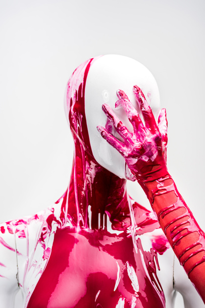 cropped image of woman in red paint touching head of mannequin isolated on white - Fotoğraf, Görsel