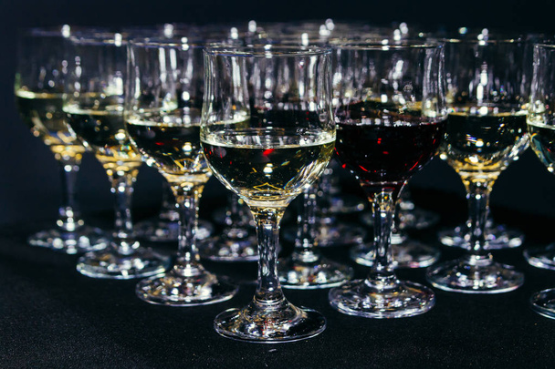 Sok szemüveg különböző bor fekete sáv pultra. Közelkép, szelektív összpontosít. - Fotó, kép