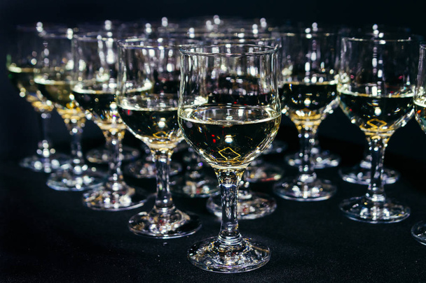 Πολλά ποτήρια διαφορετικό κρασί σε μαύρη γραμμή μετρητή. Κοντινό πλάνο, επιλεκτική εστίαση. - Φωτογραφία, εικόνα