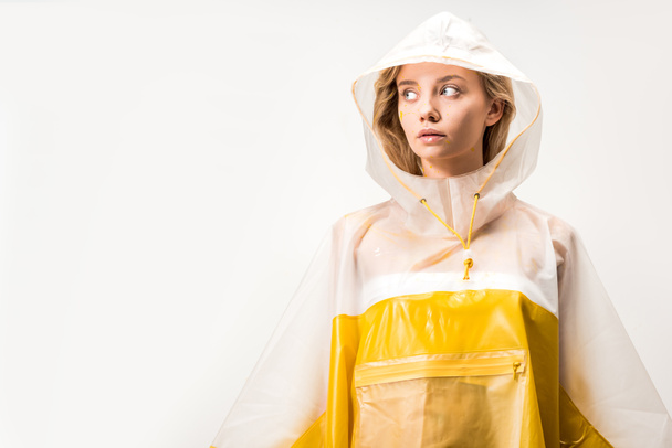 beautiful woman in yellow and white raincoat looking away isolated on white - Fotó, kép