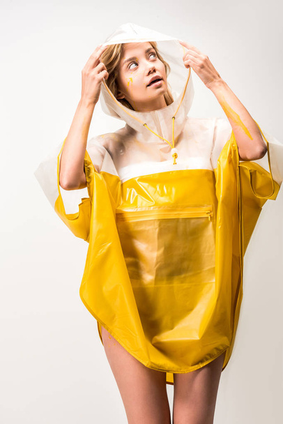 beautiful woman in raincoat holding hood and looking up isolated on white - Valokuva, kuva