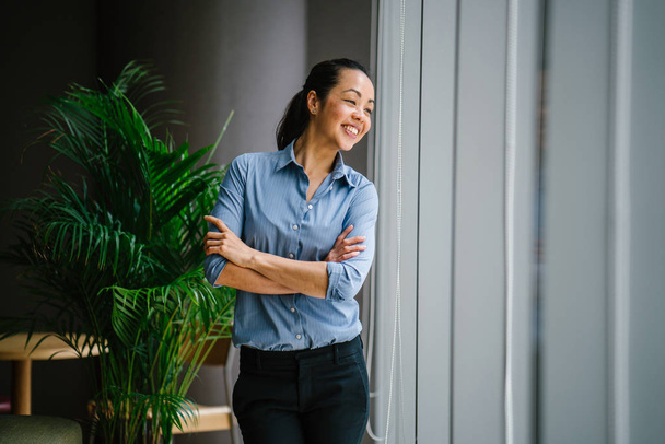 Portrait of young confident asian businesswoman standing near window  - Zdjęcie, obraz