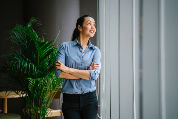 Portrait of young confident asian businesswoman standing near window  - Foto, afbeelding