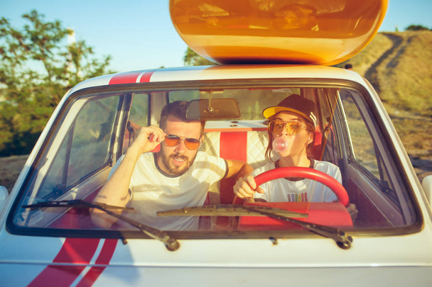 Rindo casal romântico sentado no carro, enquanto fora em uma viagem de carro no dia de verão
 - Foto, Imagem