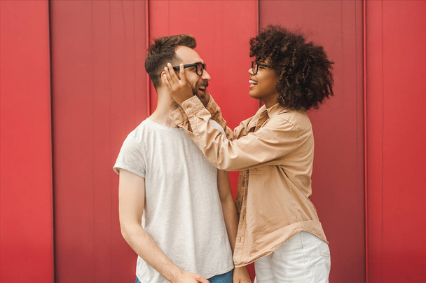 smiling young african american woman adjusting eyeglasses to handsome boyfriend - Photo, Image