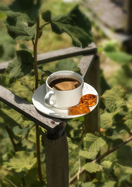 Una tazza di caffè in giardino sullo sfondo delle foglie
 - Foto, immagini