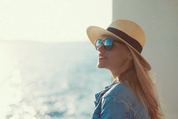 junge blonde Reisende Frauenporträt mit Hut auf Kreuzfahrtschiff, wegschauen - Foto, Bild